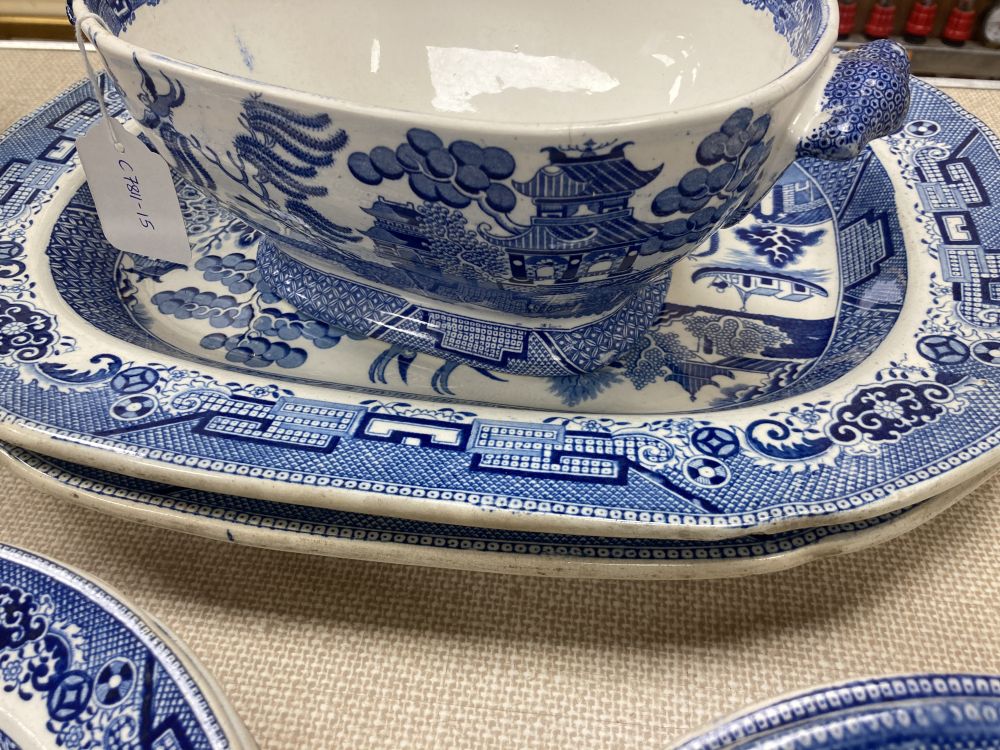 A collection of blue and white Willow pattern plates including meat platters, width 44cm and a tureen